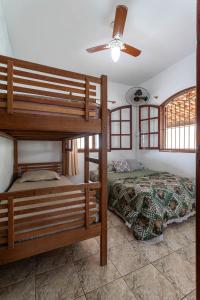 a bedroom with two bunk beds and a ceiling fan at Casa Top Arraial - Grupos e Famílias - 20 pessoas - 400 metros da praia in Arraial do Cabo