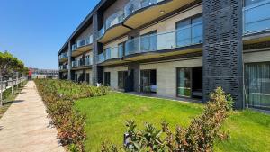 an apartment building with a lawn in front of it at Kundu Kanyon by AntalyaSuites in Antalya