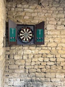 La Croix-ComtesseにあるLa Belle Évasionの石壁の窓にダーツボードが置かれている