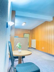 a table with chairs and a vase of flowers on it at Gästehaus Tilly in Hannoversch Münden