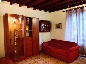 ein Wohnzimmer mit einem roten Sofa und einem Schrank in der Unterkunft Cusani 34 in Carate Brianza