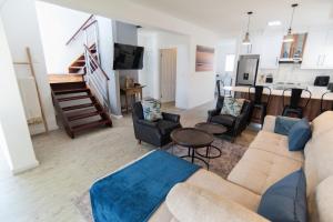 a living room with a couch and chairs and a kitchen at Waterfront Estate F13 Swakopmund in Swakopmund