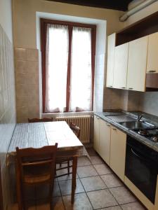 eine Küche mit einem Tisch, einer Spüle und einem Herd in der Unterkunft Cusani 34 in Carate Brianza