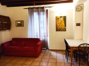 ein Wohnzimmer mit einem roten Sofa und einem Tisch in der Unterkunft Cusani 34 in Carate Brianza