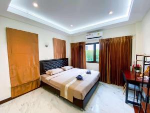 ein Schlafzimmer mit einem großen Bett und einem Schreibtisch in der Unterkunft Fhamai Pool Villa Pattaya (บ้านฟ้าใหม่ พูลวิลล่า) in Ban Huai Yai + 60 Fotos