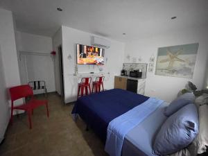 a bedroom with a bed and two red chairs at Estudios 303 in San Juan