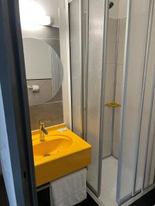 a bathroom with a yellow sink and a shower at Hôtel Amarante in Besançon +13 photos