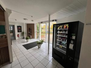 a room with a refrigerator filled with lots of drinks at Hôtel Amarante in Besançon