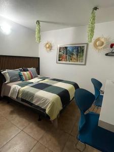 a bedroom with a bed and two blue chairs at Estudios 303 in San Juan