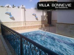 a swimming pool with birds flying over a fence at Bonne Vie Hotel in 6th Of October