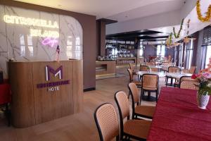 un restaurant avec des tables, des chaises et un panneau dans l'établissement MM Heritage Hotel, à Malacca