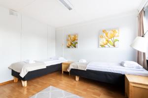 two beds in a room with white walls at Functional and cozy 3 bedroom apartment for 6 in Myyrmäki