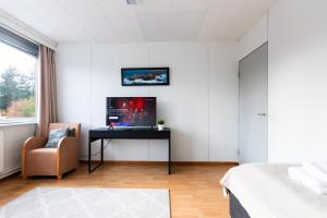 a bedroom with a desk with a tv and a chair at Functional and cozy 3 bedroom apartment for 6 in Myyrmäki
