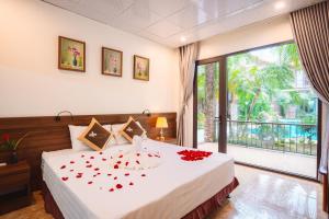une chambre avec un lit avec des fleurs rouges dessus dans l'établissement Tam Coc Little Charm Villa & Bungalow, à Văn Lâm 24 autres photos