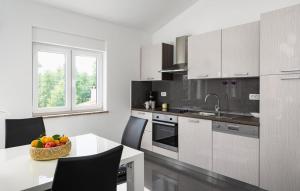 a kitchen with white cabinets and a table with a bowl of fruit at Villa Iva by Villas Guide in Pazin +10 photos
