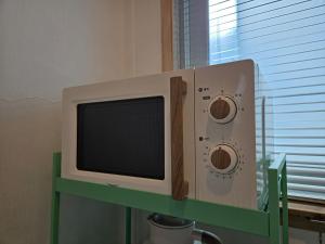 a tv sitting on a green table in front of a window at 스테이 노랑 stay norang in Daegu