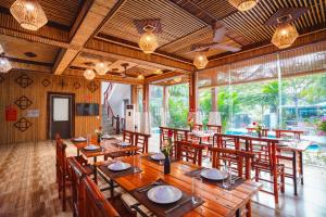 une salle à manger avec une grande table et des chaises en bois dans l'établissement Tam Coc Little Charm Villa & Bungalow, à Văn Lâm