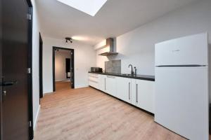 a kitchen with white cabinets and a wooden floor at The Vault - Eindhoven - By T&S in Eindhoven