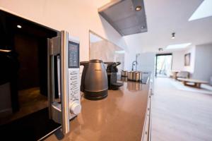 a kitchen with a counter with pots and a microwave at The Vault - Eindhoven - By T&S in Eindhoven