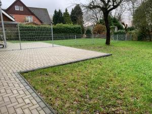 a park with a fence and a tree and grass at Modern 4-bedroom apartment near Hamburg in Rosengarten