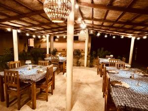 a restaurant with tables and chairs under a pergola at Nino Lodge in Samba Dia