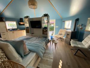 a living room with blue walls and a bed and chairs at Van Egmond suites Mr Blue Sky in Anna Paulowna