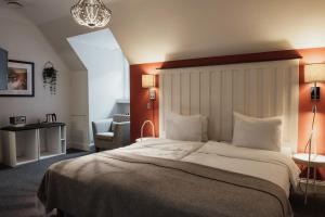 a bedroom with a large bed and a chair at Home Hotel Grand Helsingborg in Helsingborg