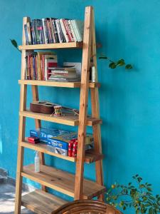 a wooden book shelf with books on it at Vin's Villa & caffe in Bīr