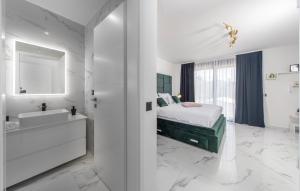 a white bedroom with a bed and a tub and a sink at Villa Karla with pool&sea view by Villas Guide in Rab +52 photos