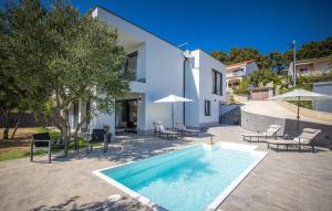 a swimming pool in front of a house at Villa Karla with pool&sea view by Villas Guide in Rab
