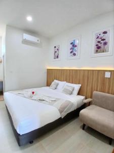 a bedroom with a large bed and a chair at ศรีทองคูณ เชียงคาน ซอย4 in Chiang Khan