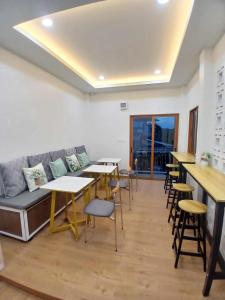 a living room with a couch and tables and chairs at ศรีทองคูณ เชียงคาน ซอย4 in Chiang Khan