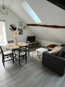 a living room with a table and a couch at Le petit cloître in Langres