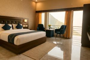 Una habitación de hotel con una cama y un escritorio con sillas. en River Grand Hotel - Best Property of Mussoorie 2024-25, en Mussoorie