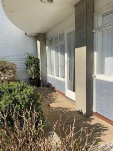 a porch of a building with windows and plants at Beautiful 2 bed grd floor flat fantastic location in Eastbourne