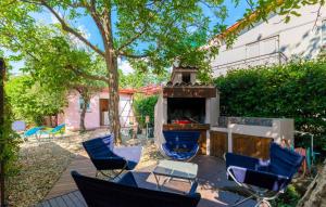 a patio with chairs and a fireplace in a yard at Ferienhaus Nina mit Whirpool by Villas Guide in Selce