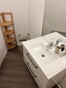 a bathroom with a white sink and a toilet at Le petit cloître in Langres