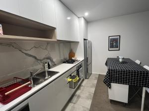 a small kitchen with a sink and a table at Where Style Meets Convenience in Melbourne CBD in Melbourne +2 photos