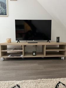a television on a wooden entertainment center in a living room at Le petit cloître in Langres +10 photos