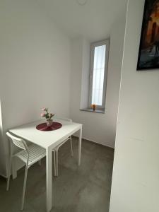 a white table and chair in a room with a window at Schönes Zimmer-1 in Stuttgart-Mitte in Stuttgart