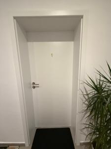 a white door in a room with a plant at Schönes Zimmer-1 in Stuttgart-Mitte in Stuttgart