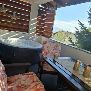 Un balcón con bañera y mesa en Apartment Casa Sarajevo, en Sarajevo