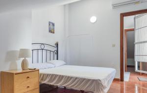 a white bedroom with a bed and a dresser at 3 Bedroom Gorgeous Apartment In Malaga in Málaga