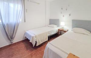 a white room with two beds and a window at 3 Bedroom Gorgeous Apartment In Malaga in Málaga