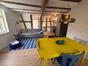 a yellow dining table and chairs in a living room at Zur Traube - blau in Erbach im Odenwald