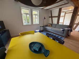 a living room with a yellow table and a couch at Zur Traube - blau in Erbach im Odenwald