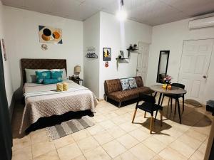 Un dormitorio con una cama, una silla y una mesa. en Sunzal Loft, WSL Ecovilla Surfing, en El Sunzal 30 fotos más