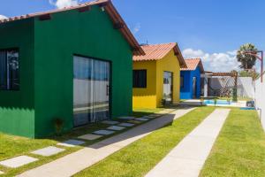 a row of colourful houses in a yard at Chalé 3 Reis Bg in Barra Grande