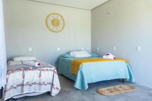a bedroom with two twin beds and a table at Chalé 3 Reis Bg in Barra Grande