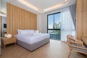 ein Schlafzimmer mit einem weißen Bett und einem großen Fenster in der Unterkunft Bangtao Brand New Luxury Modern Pool Villa Laguna Phuket in Thalang + 80 Fotos